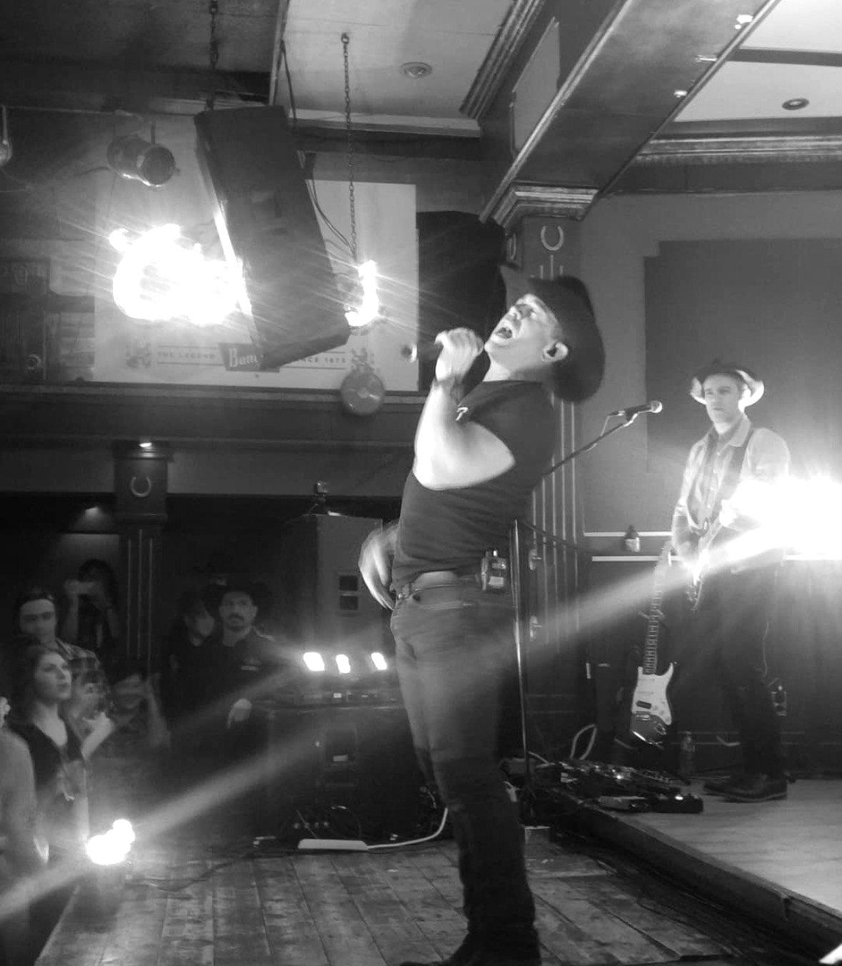 A country singer performing on stage with his band